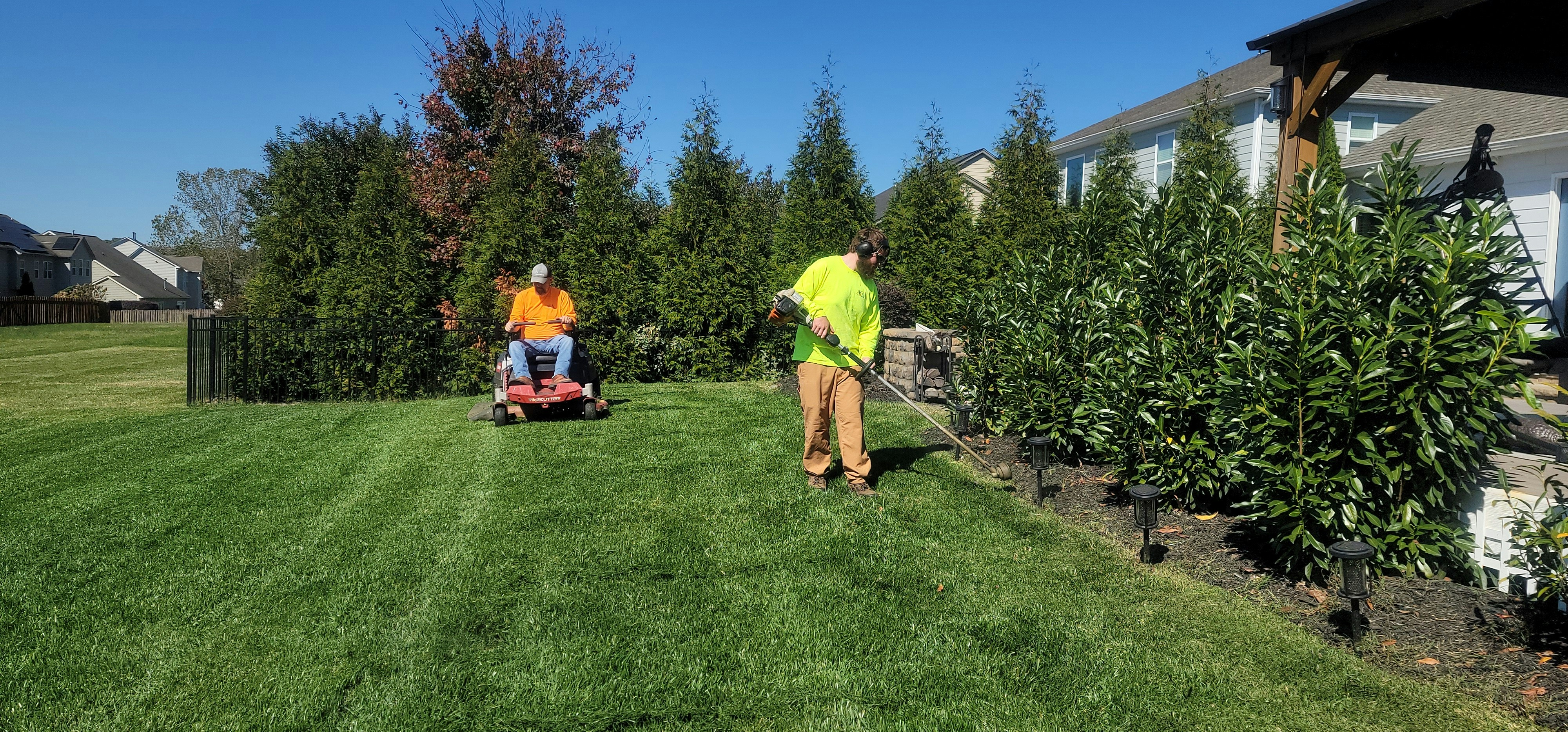 Lawn care crew mowing and edging a residential lawn