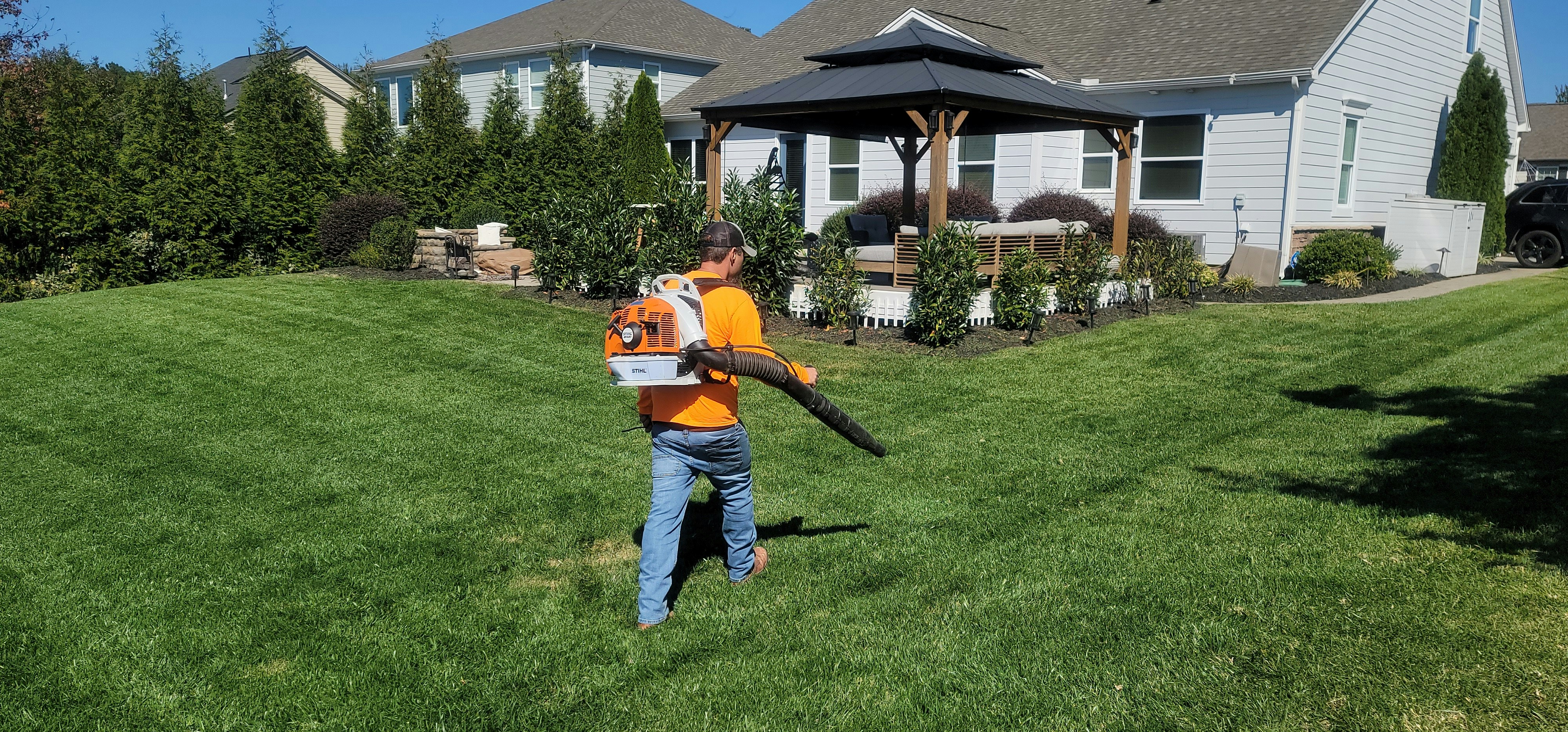 Lawn care professional maintaining a residential yard